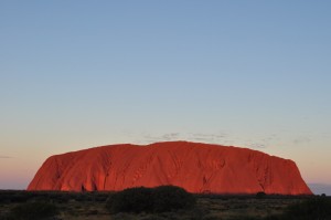 Vista of Uluru at sunset, reflecting red and gold