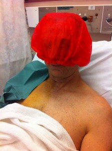 In his hospital gown and red cap