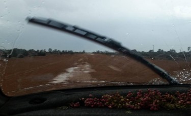 Rain on the windscreen, puddles and mud on the road