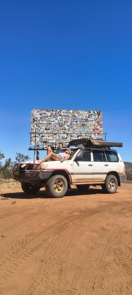 Lying on my car in front of the Gibb River Road sign